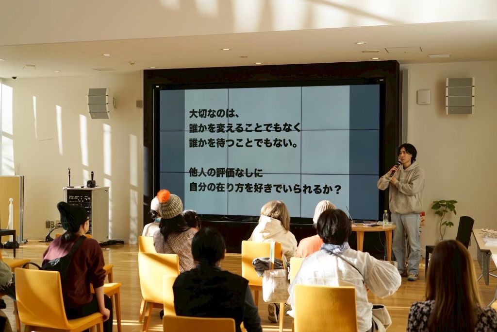 講演会で話す講師と、席に座って聞く参加者